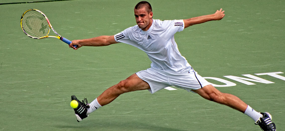 Ljósmyndin sýnir mann leika tennis.
