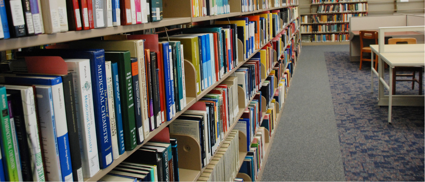 Ljósmynd af bókahillu fullri af bókum um lyfja- og lækningaefnafræði á efna- og eðlisfræðibókasafni Kent State University.