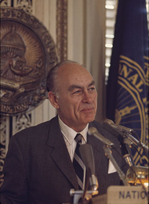 George Gallup flytur ræðu við ræðupúlt.