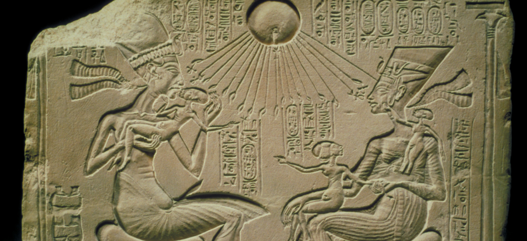 Útskorinn steinbrot sýnir tvær fullorðnar manneskjur halda á börnum. Fyrir ofan þau er sólin og geislar hennar ná niður að fullorðna fólkinu og börnunum. Egypsk myndleturstákn umlykja myndirnar.