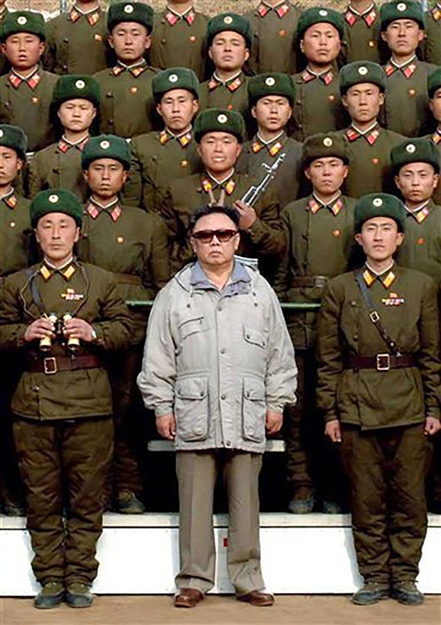Kim Jong-il frá Norður-Kóreu stendur með sólgleraugu innan um hóp norðurkóreskra hermanna í einkennisbúningum.