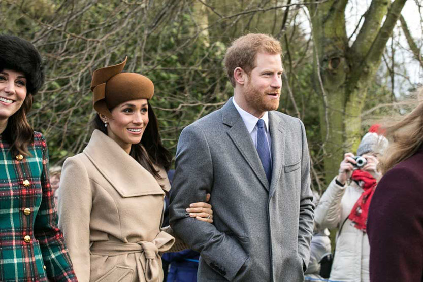 Meghan Markle og Harry prins standa við hlið Katrínar, hertogaynju af Cambridge, á meðan fólk tekur af þeim myndir.