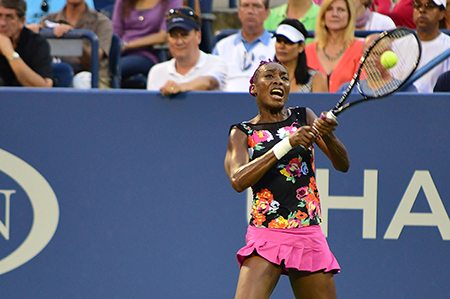 Ljósmynd af Venus Williams að slá tennisbolta með tennisspaða.